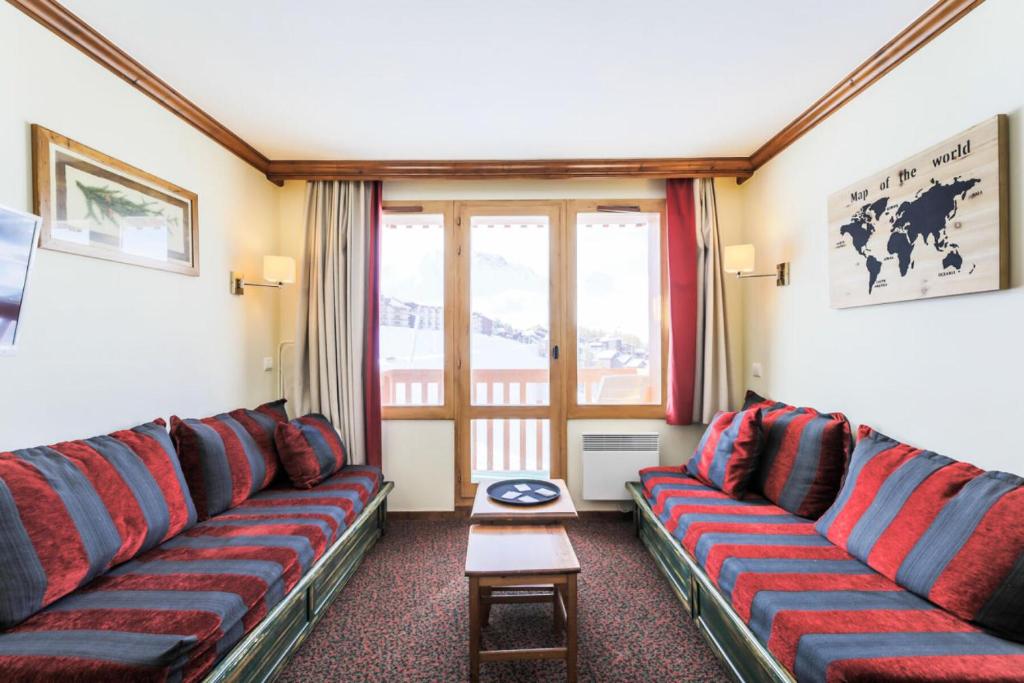 - un salon avec des canapés rouges et bleus et une table dans l'établissement Résidence Le Mont Soleil - maeva Home - Appartement 2 pièces 5 personnes - Sélection MAE-0302, à Mâcot La Plagne