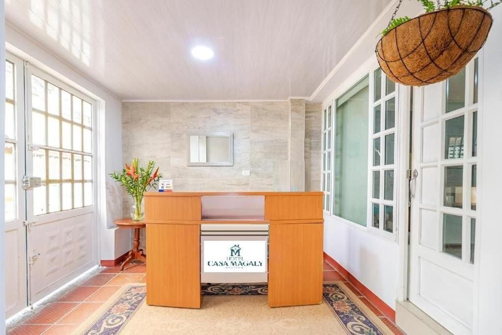 a room with a table in a room with windows at Hotel Boutique Casa Magaly in Bogotá