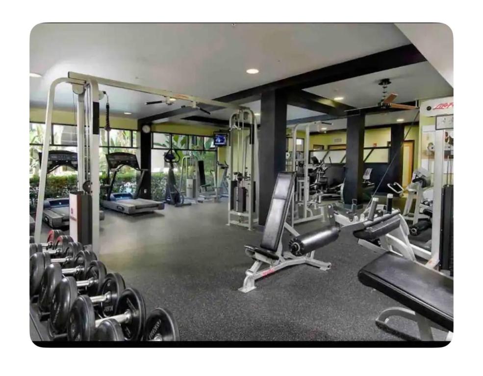 a gym with several treadmills and machines in it at Entire Apartment (Los Angeles) in Los Angeles