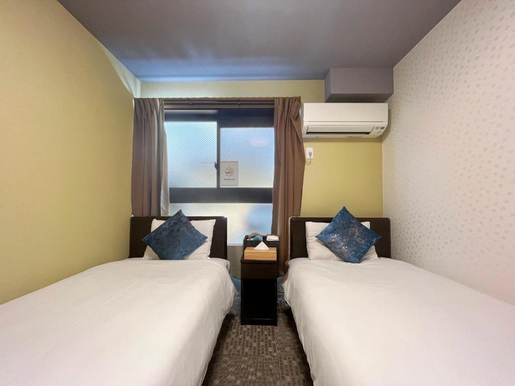 京都市にあるMiro Kyoto Nijo Hotel - Vacation STAY 41092vのベッド2台と窓が備わる客室です。