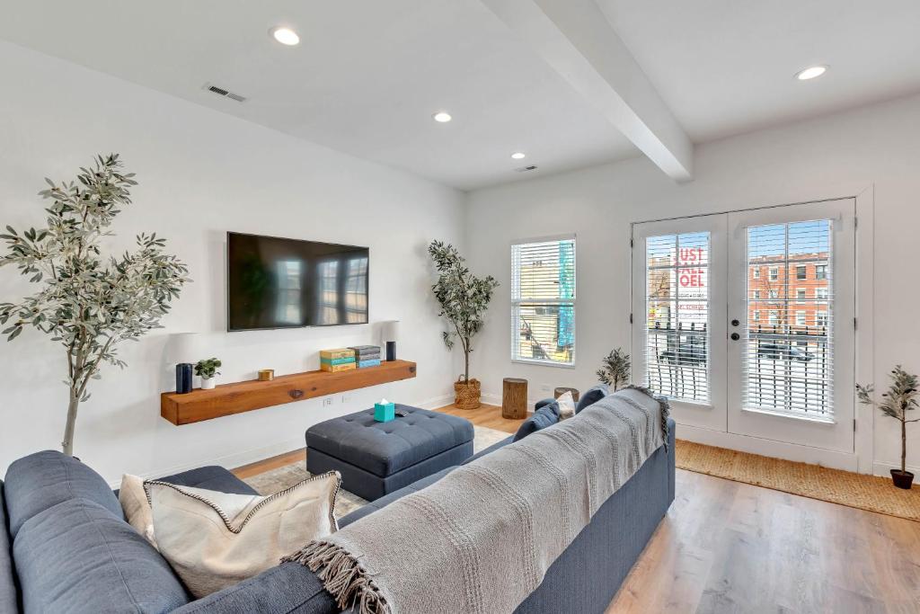 a living room with a large couch and a tv at Bright Modern 4Bd 2Ba in the Heart of Wrigleyville condo in Chicago