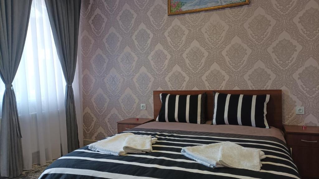 una camera da letto con un letto e due asciugamani di Готель Ассоль a Chmel'nyc'kyj