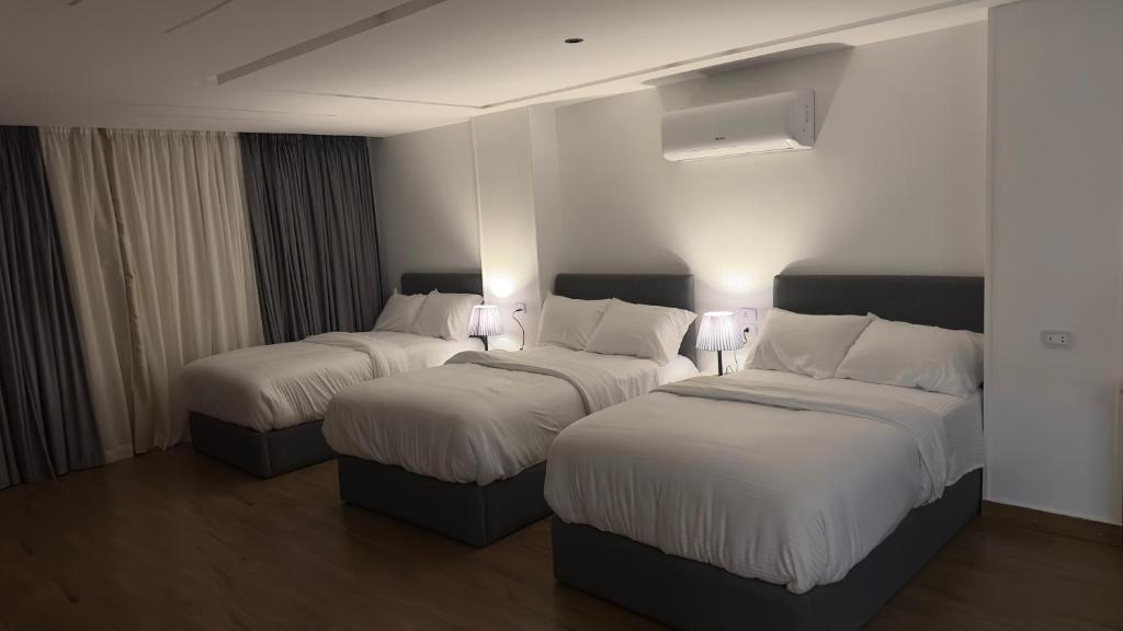 twee bedden in een hotelkamer met verlichting erop bij لوكاندة الحصري أكتوبر motel elhosary in Zes oktober (stad)