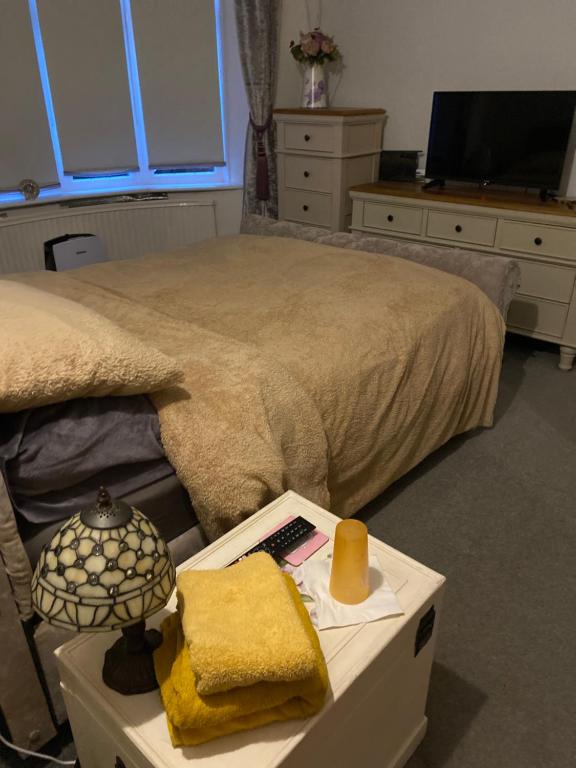 South Bank的住宿－Holmhurst，一间卧室配有一张床和一张桌子,床上铺有四柱床。