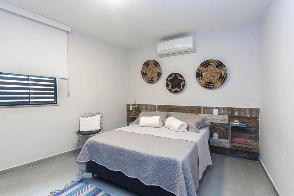 a bedroom with a bed and two plates on the wall at Pê na areia Loft Praia de Itaipú in Itaipu
