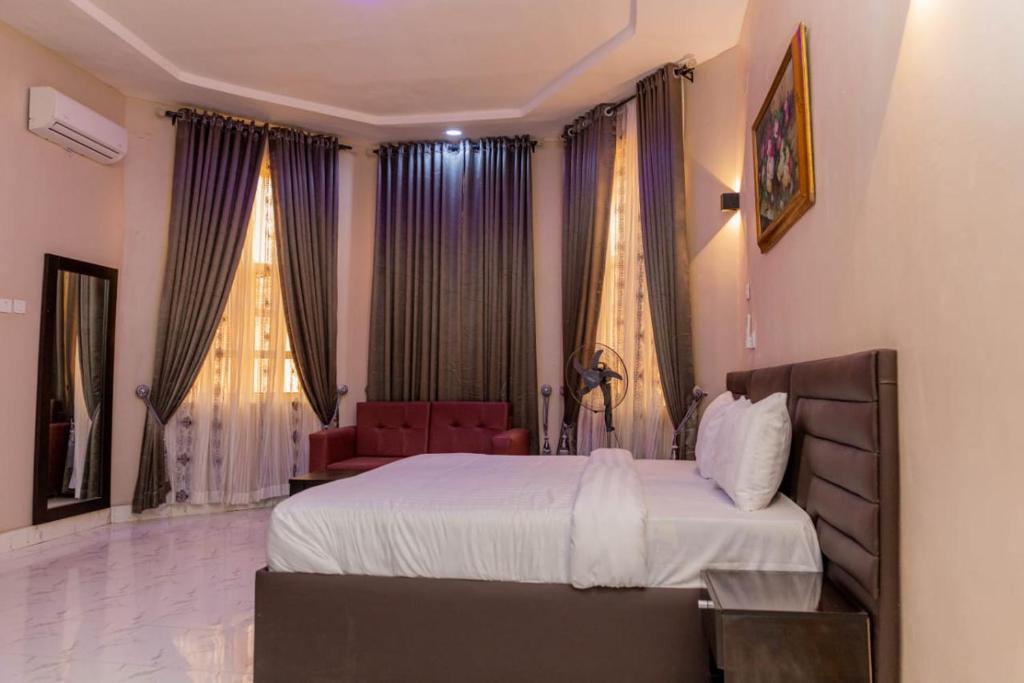 ein Schlafzimmer mit einem Bett und einem Stuhl darin in der Unterkunft Yona Resort Inn in Ijebu Ode