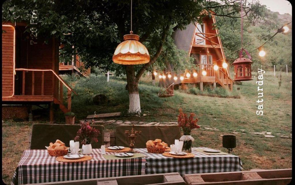 a table with food on it in a yard at Teo's Cottages in Dedoplis Tskaro