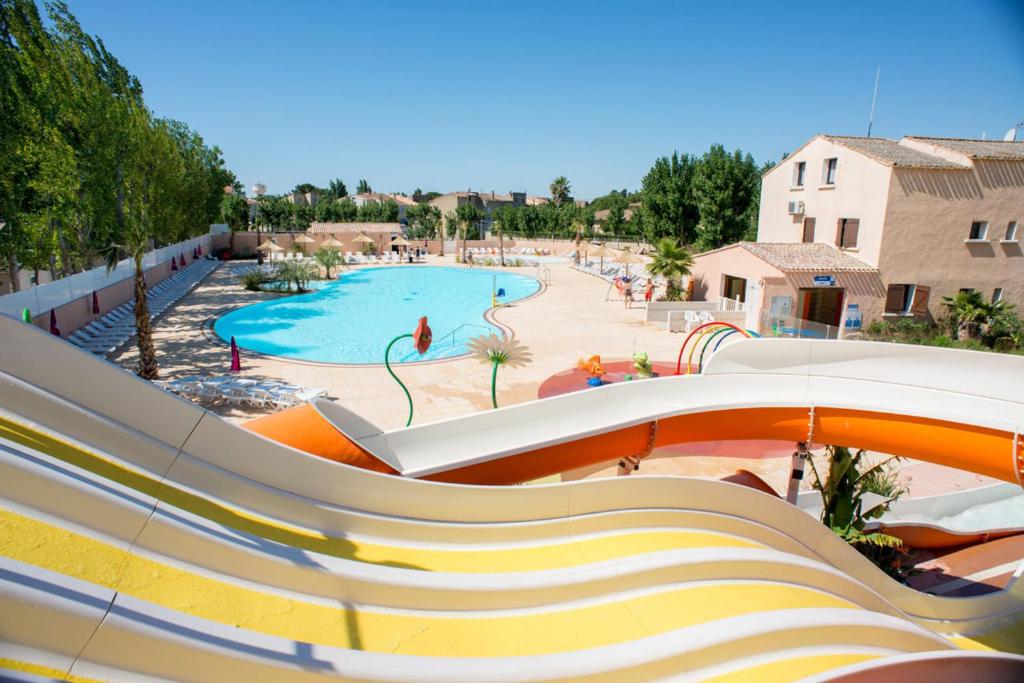 a slide at a resort with a swimming pool at Mobil home les sables du midi 4 étoiles in Valras-Plage