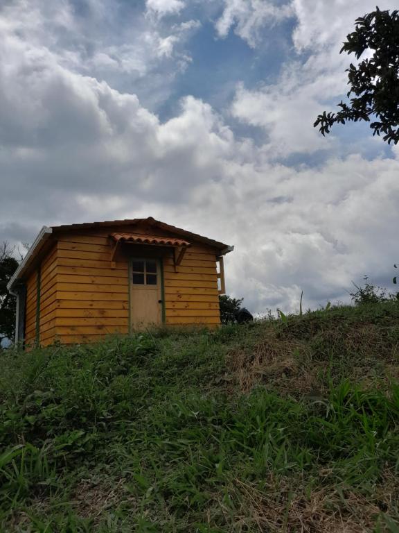 una pequeña casa de madera en una colina con un cielo en CABAÑA RURAL DURANGO, en Salento