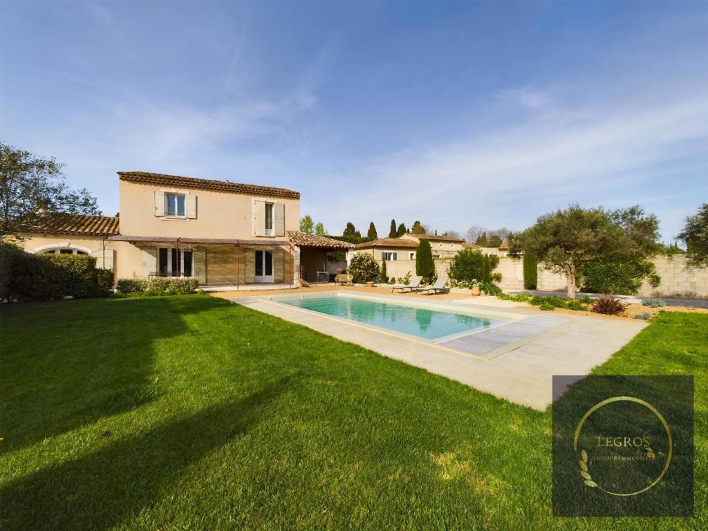 une maison avec une piscine dans une cour dans l'établissement Maison la Garrigue en Provence, à Maillane