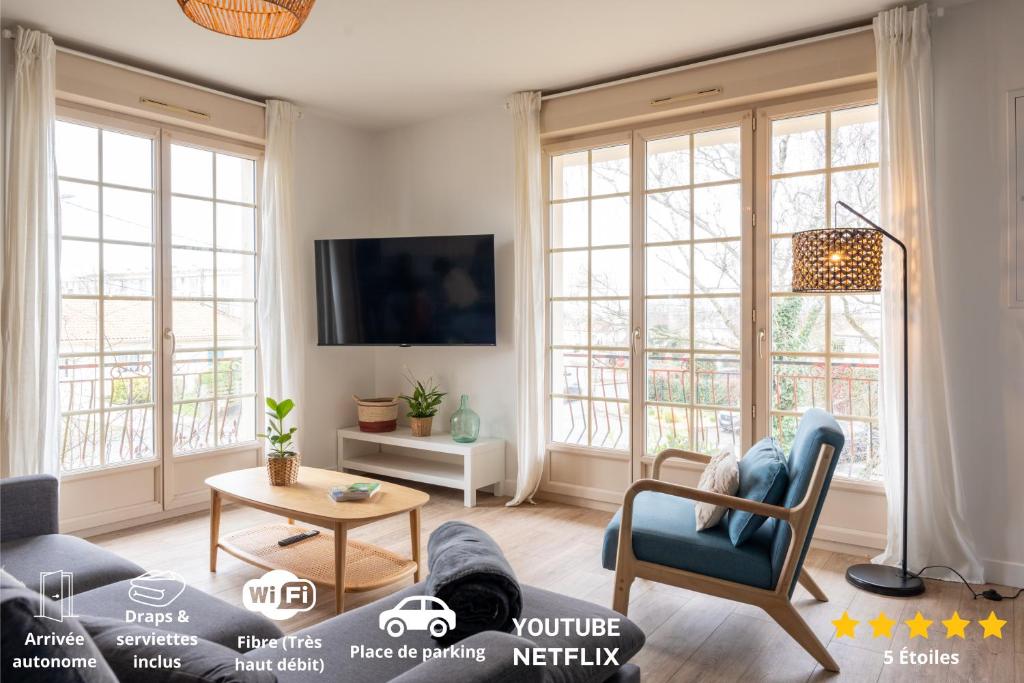 a living room with a couch and chairs and windows at Le Noyer - moderne - spacieux - parking in Montaigu-Vendée