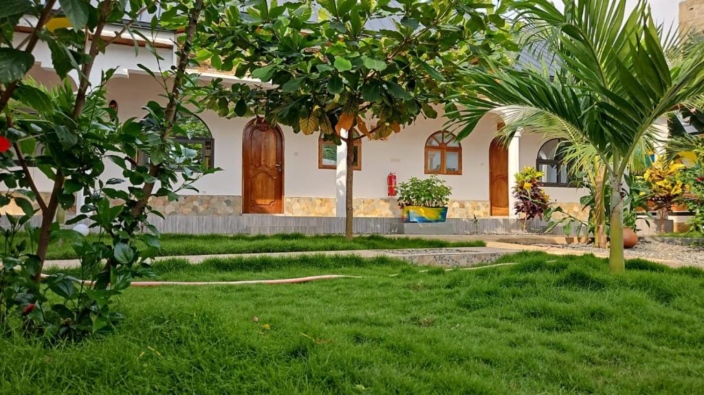 uma casa com uma palmeira no quintal em Hotel Eyram Kpalime em Palimé