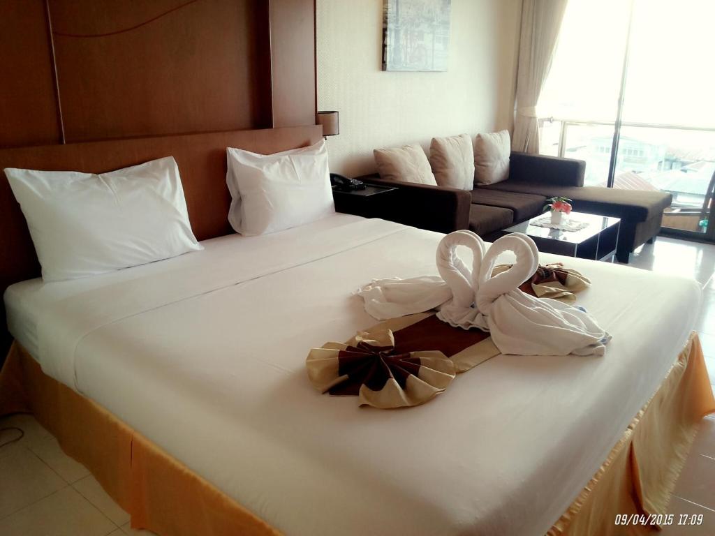 a hotel room with a bed with a bow on it at Seaview Sriracha Hotel in Si Racha