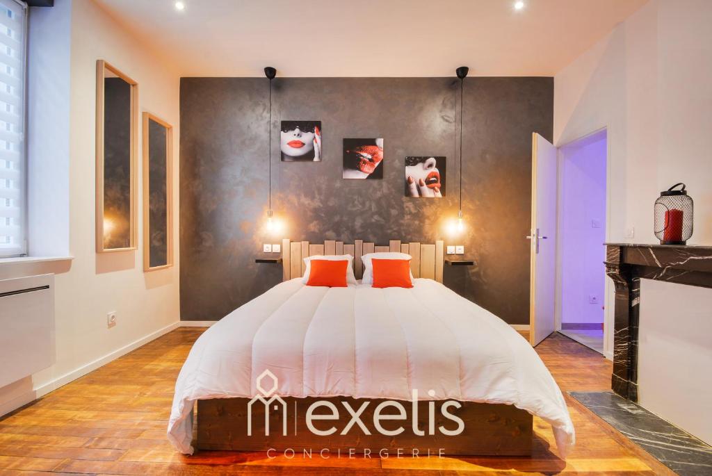 a bedroom with a bed with orange pillows and a fireplace at Charles sous le Charme in Nancy