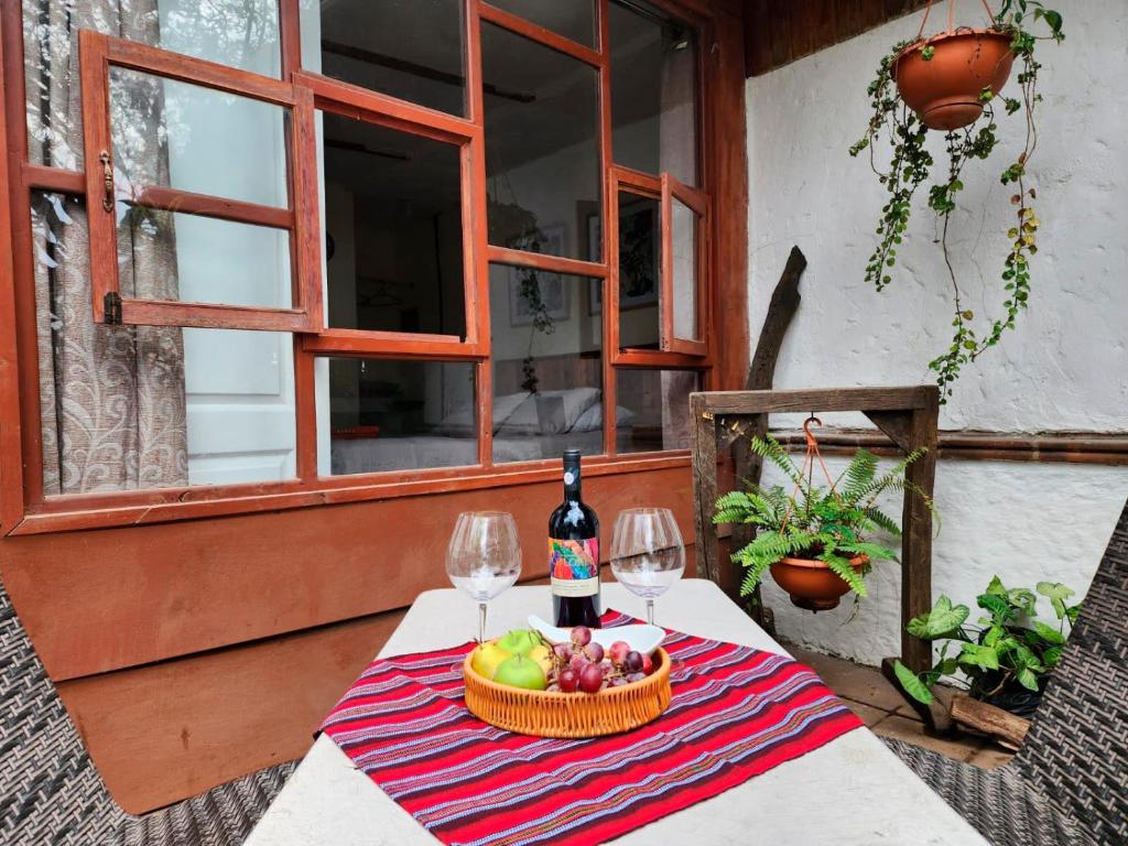una mesa con una cesta de fruta y una botella de vino en CABAÑAS EN ZONA 16 en Guatemala
