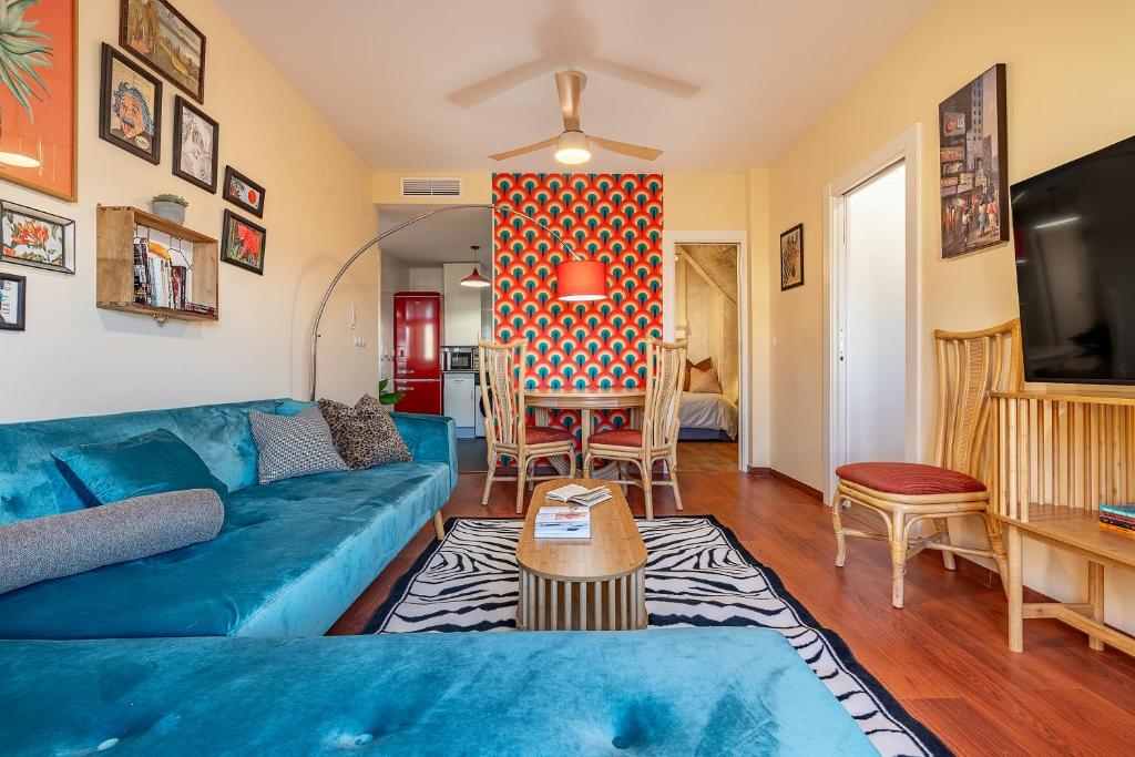 a living room with a blue couch and a table at Mirador del Ocaso in La Zubia