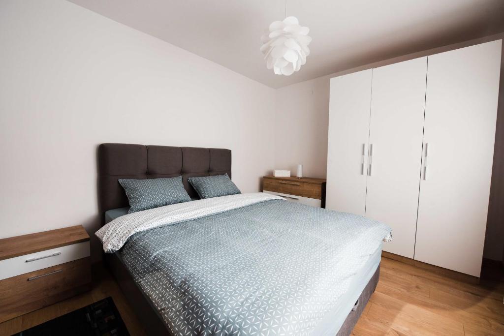 a bedroom with a bed and a chandelier at Apartment Jazz in Požega