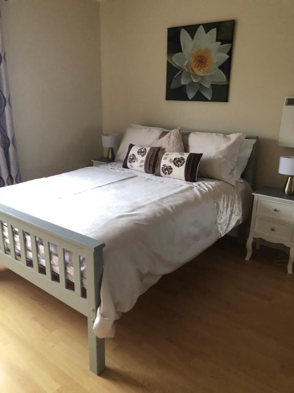 un letto con lenzuola e cuscini bianchi in una camera da letto di Riverside a Doonbeg