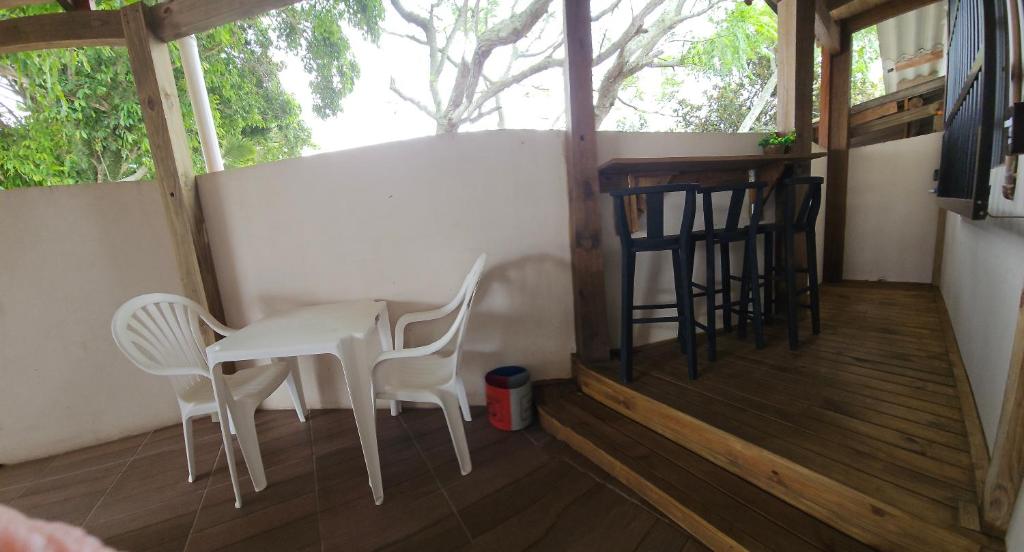 um pequeno alpendre com duas cadeiras e uma mesa em Casa Canto do Farol em Navegantes