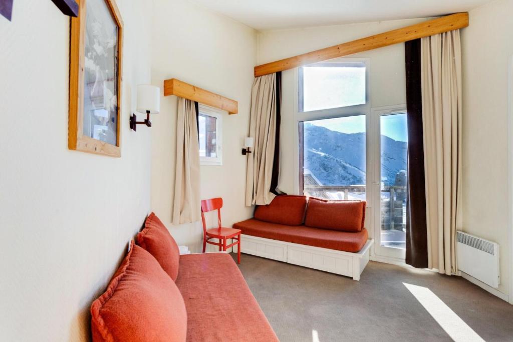 a living room with a red couch and a window at Résidence Quartier Falaise - maeva Home - Appartement 2 Pièces 7 Personnes - Sélection MAE-0584 in Avoriaz