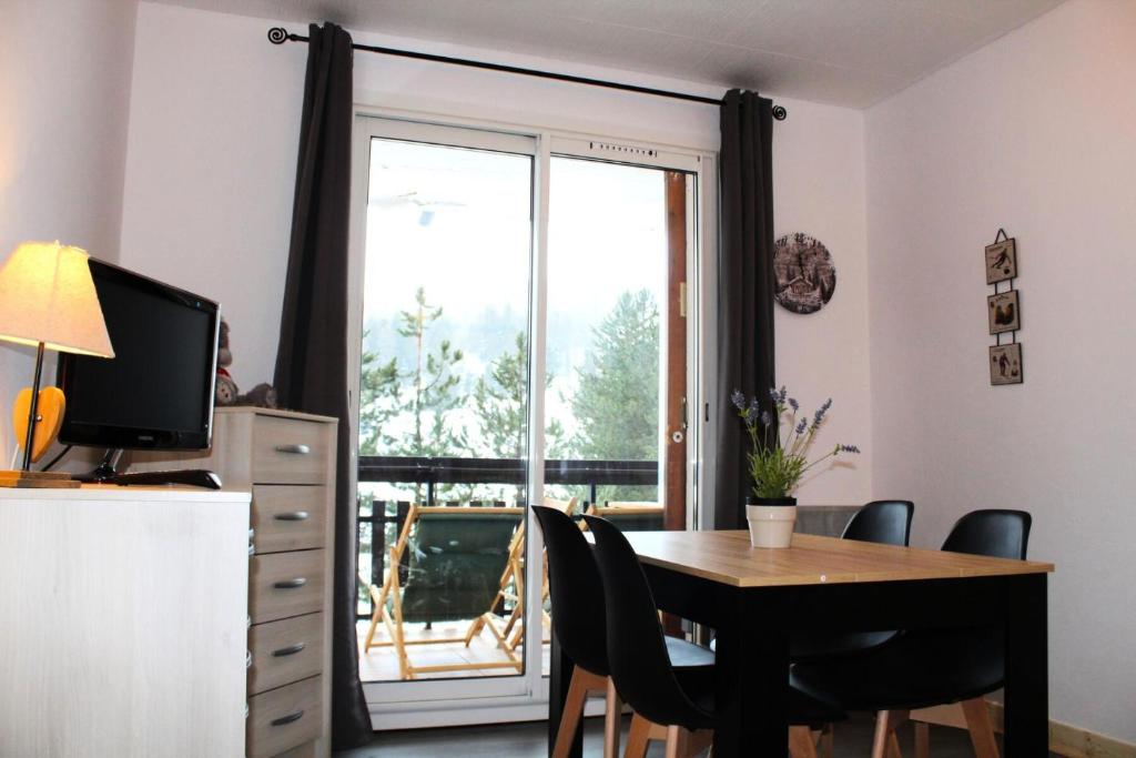une salle à manger avec une table et des chaises et une fenêtre dans l'établissement Résidence Les Issarts - APPARTEMENT AU PIED DES PISTES MAE-9761, à Saint-Étienne-en-Dévoluy