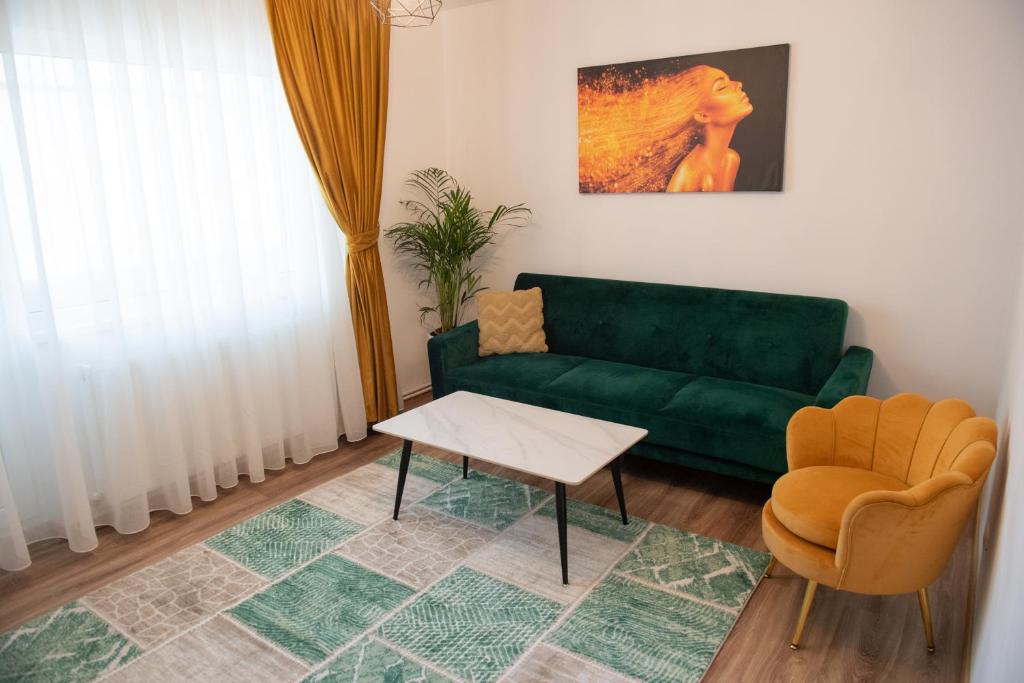 a living room with a green couch and a table at Cosy retreat in Piatra Neamţ