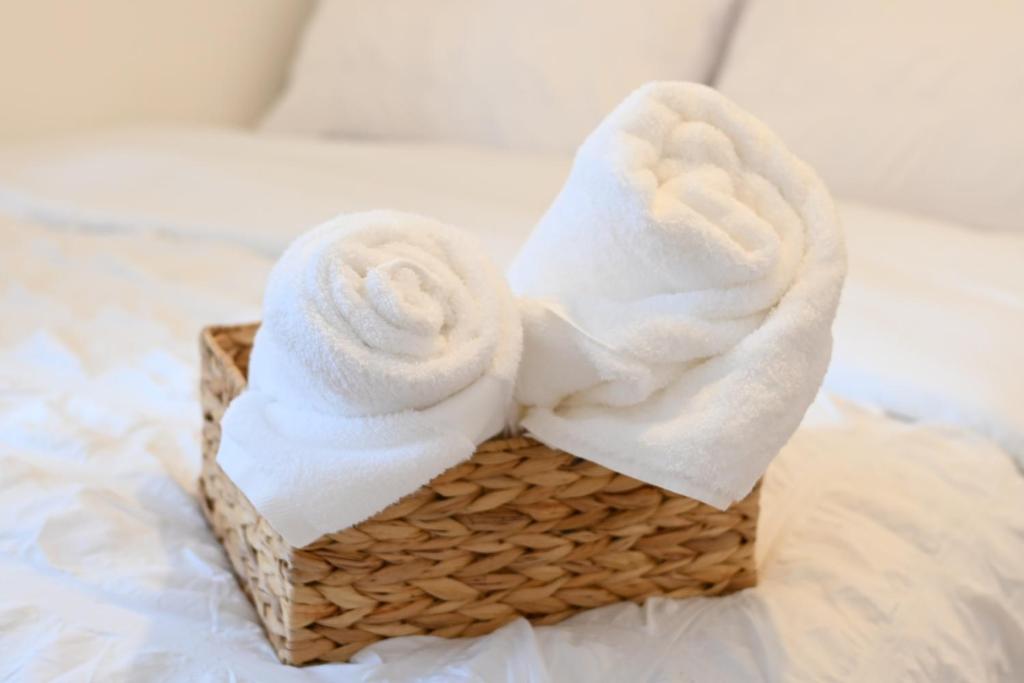 a basket filled with towels on a bed at Unique and luxury city center apartment with free parking in Southampton
