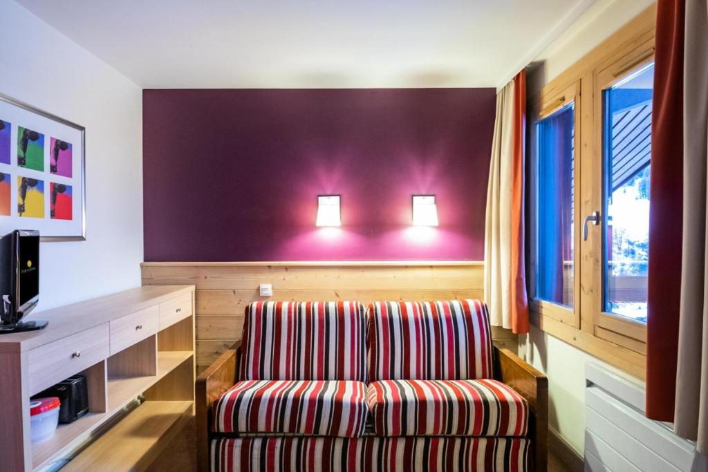 une chambre avec une chaise et deux lumières sur un mur dans l'établissement Résidence Plagne Lauze - maeva Home - Studio 4 personnes - Budget MAE-0934, à Mâcot La Plagne