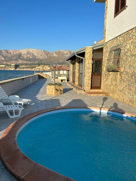einem Pool vor einem Gebäude mit Wasser in der Unterkunft casa vacanza barbera - In Riva al Mare in Trappeto