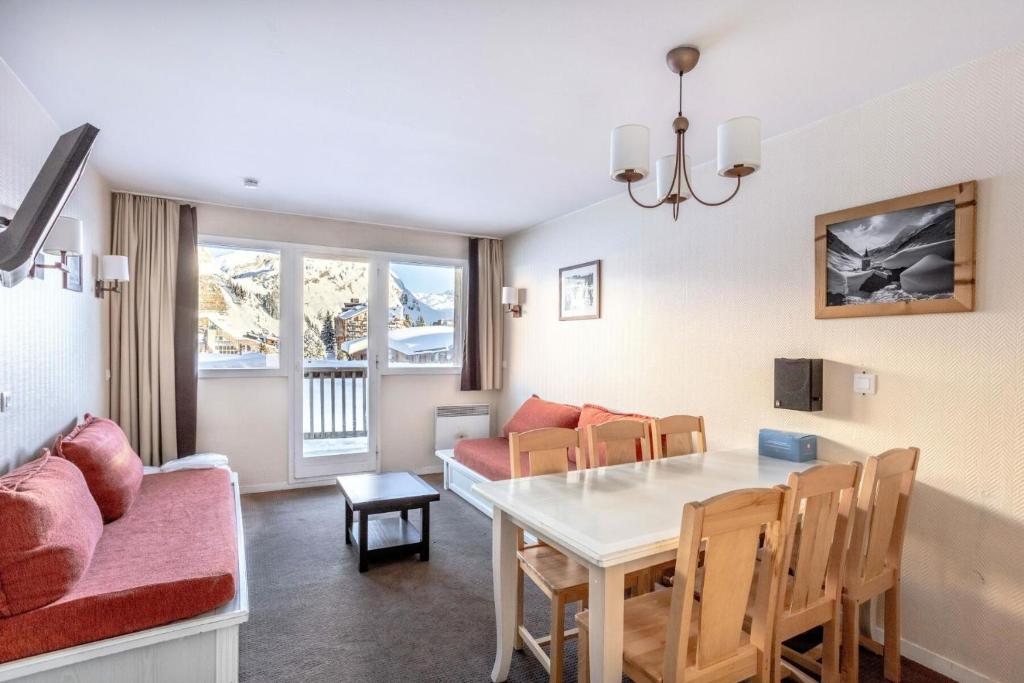 une salle à manger et un salon avec une table et des chaises dans l'établissement Résidence Quartier Falaise - maeva Home - Appartement 2 Pièces 6 Personnes - Prestige MAE-3854, à Avoriaz