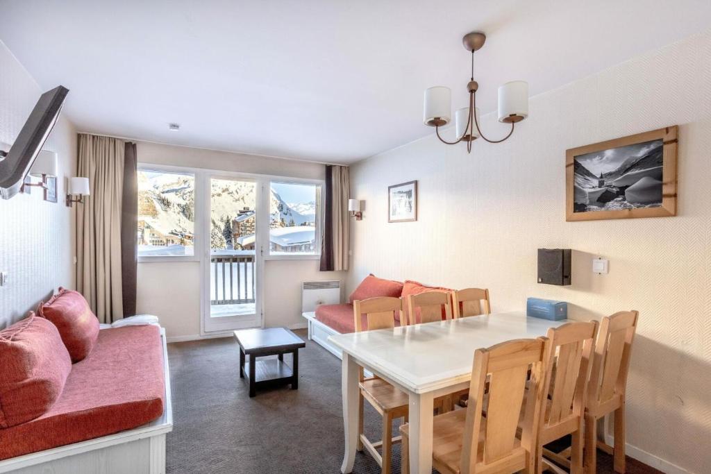 a dining room and living room with a table and chairs at Résidence Quartier Falaise - maeva Home - Appartement 2 Pièces 6 Personnes 854 in Avoriaz