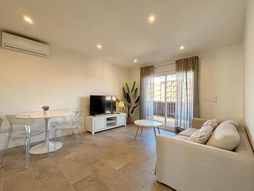 a living room with a couch and a table and a tv at Clauhomes Suite Center in Tarragona