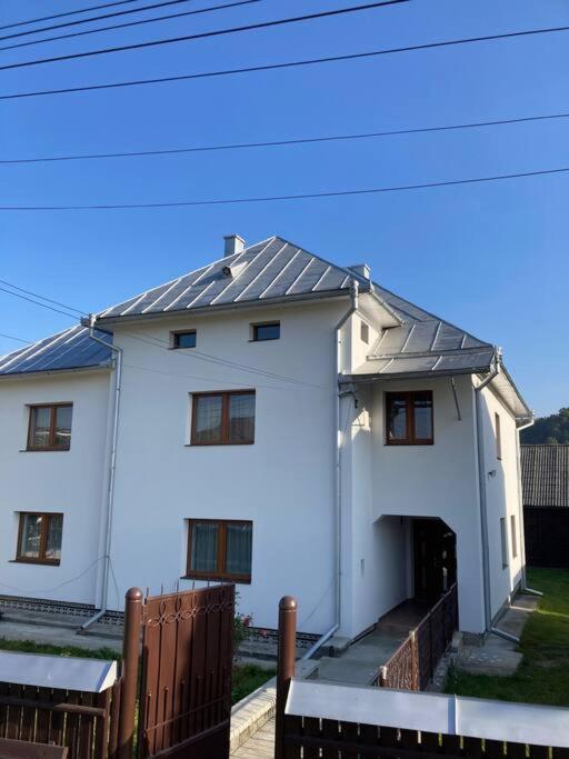 a white house with a metal roof at Trai bun in Maramures in Fereşti