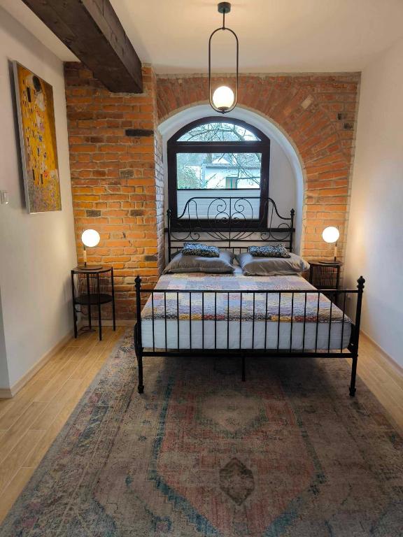 a bedroom with a bed in a brick wall at Loft pod Starym Kasztanem in Krynica Zdrój
