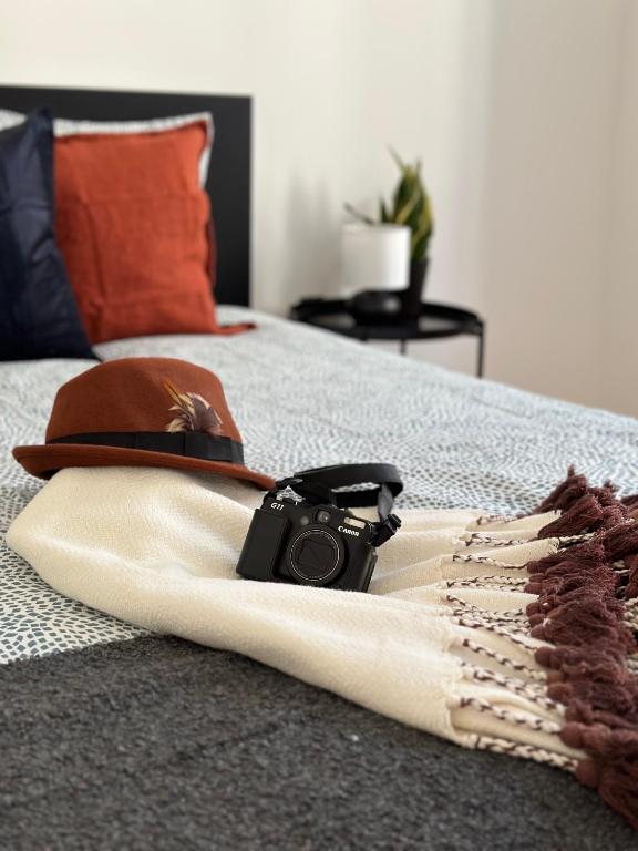 un appareil photo et un chapeau sur un lit dans l'établissement New Baixa Chiado Bedrooms, à Lisbonne