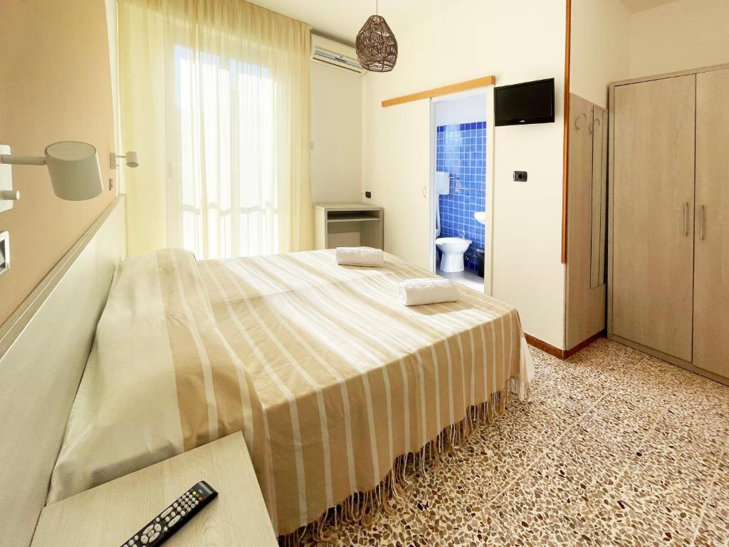 a bedroom with a bed and a remote control at Hotel Reale in Rimini