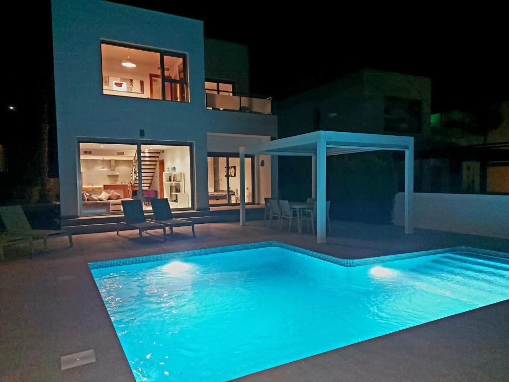 a swimming pool in front of a house at night at Modern Villa Frontline Golf in Algorfa