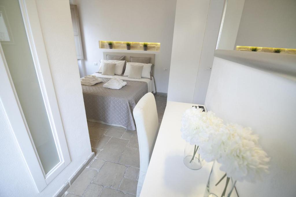 ein kleines Zimmer mit einem Bett und einer Blumenvase auf einem Tisch in der Unterkunft Numero 85 in Termoli