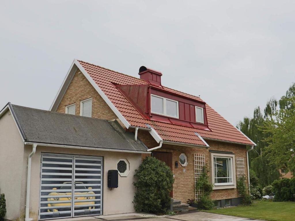 ein Haus mit einem roten Dach und einer Garage in der Unterkunft Holiday home FALKENBERG XXIX in Falkenberg