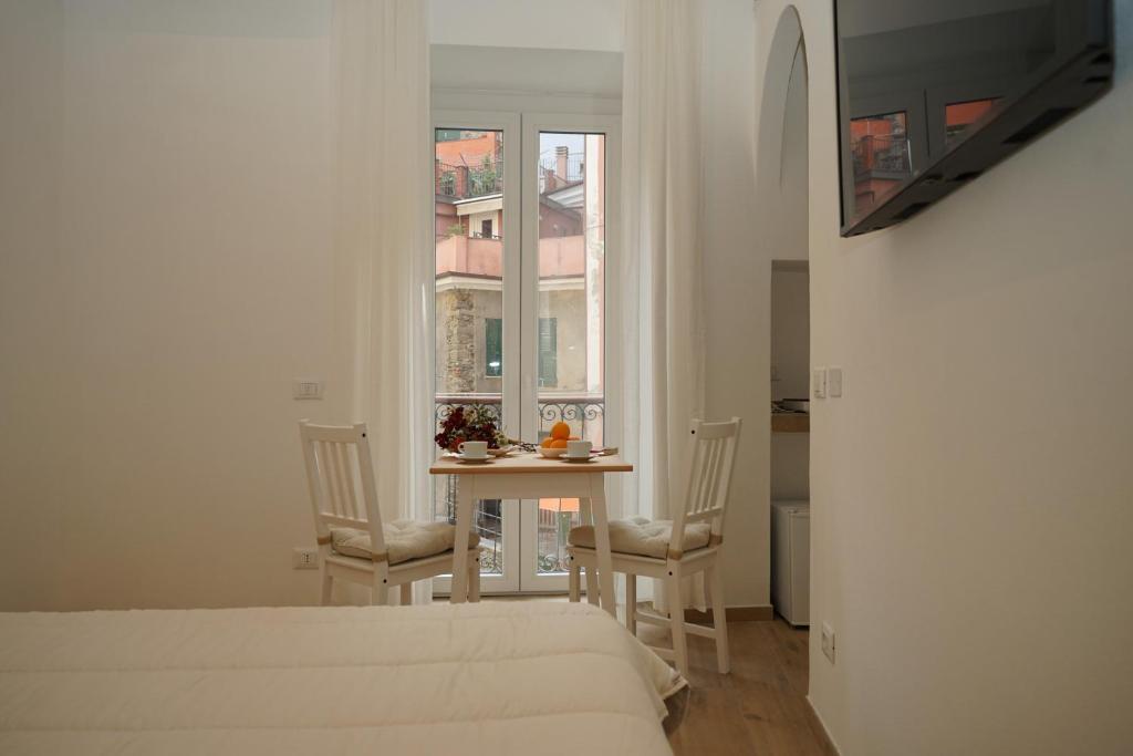 een slaapkamer met een bed en een tafel en stoelen bij Les pieds dans l'eau Vernazza in Vernazza