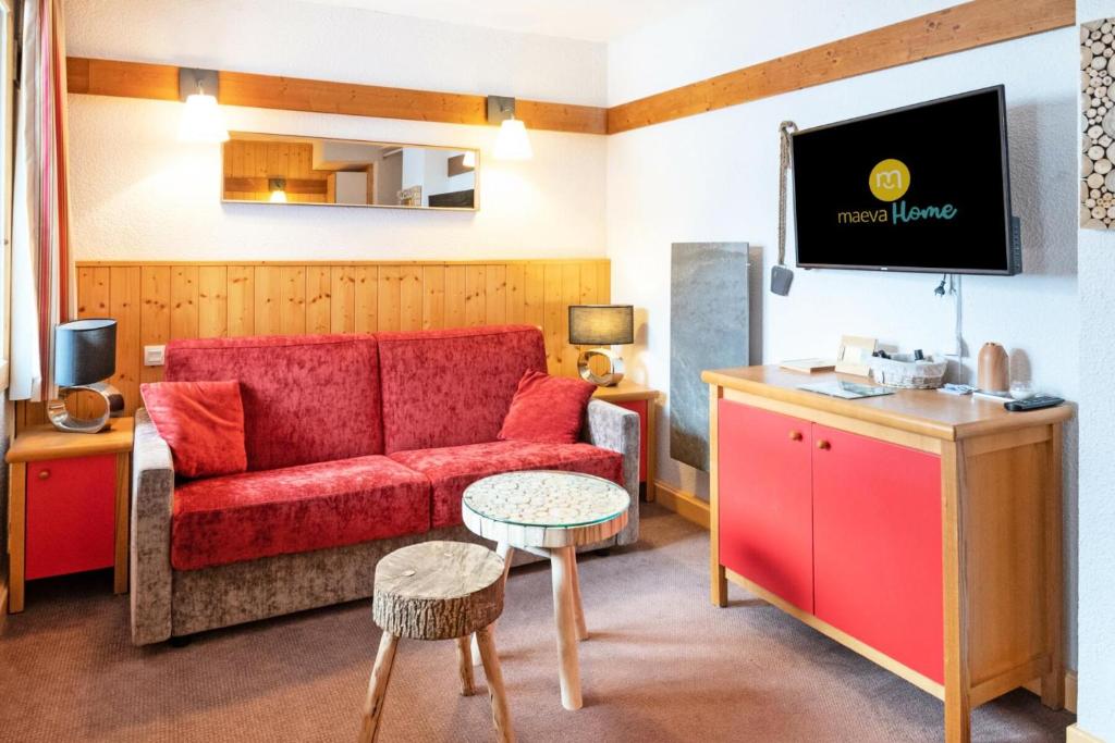 un salon avec un canapé rouge et une télévision dans l'établissement Résidence Plagne Lauze - maeva Home - Studio 4 personnes - Confort MAE-7594, à Mâcot La Plagne