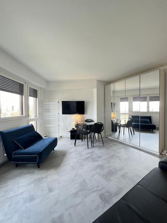 uma sala de estar com um sofá azul e uma mesa em Apartment with view of Paris 15 min to the center, next to subway station and Olympic village em Paris