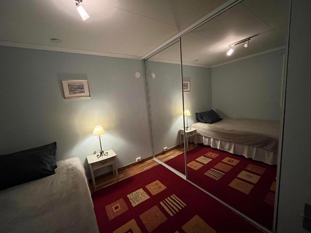 Habitación pequeña con 2 camas y espejo. en Maaloey Fjord & Mountain Panorama en Måløy