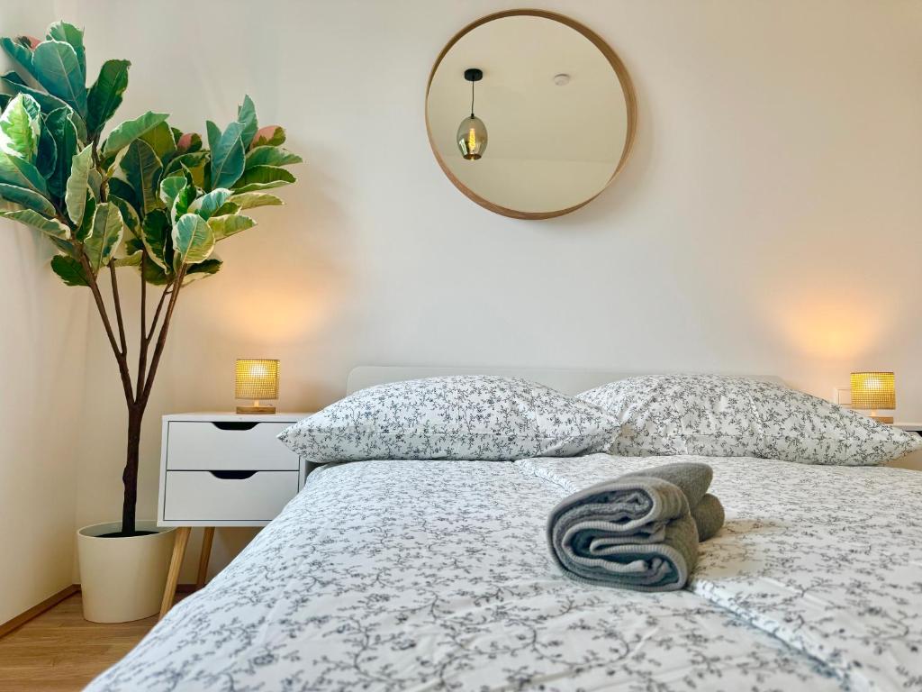 1 dormitorio con cama con almohadas y espejo en Modern Premium Apartment with Balcony en Viena
