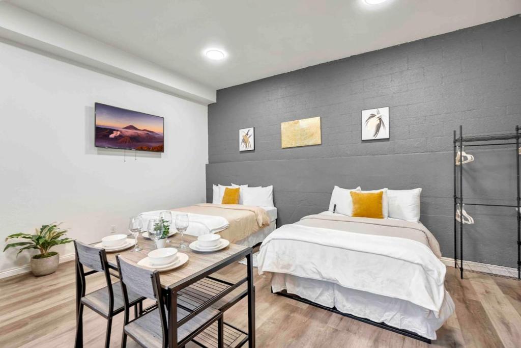 een slaapkamer met 2 bedden en een tafel met stoelen bij Downtown Pomona Private Studio with Private Access in Pomona