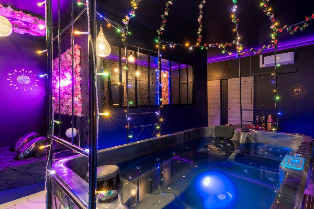 wanna z hydromasażem w pokoju z lampkami choinkowymi w obiekcie Sweet SECRET'S JACUZZI w mieście Le Breuil