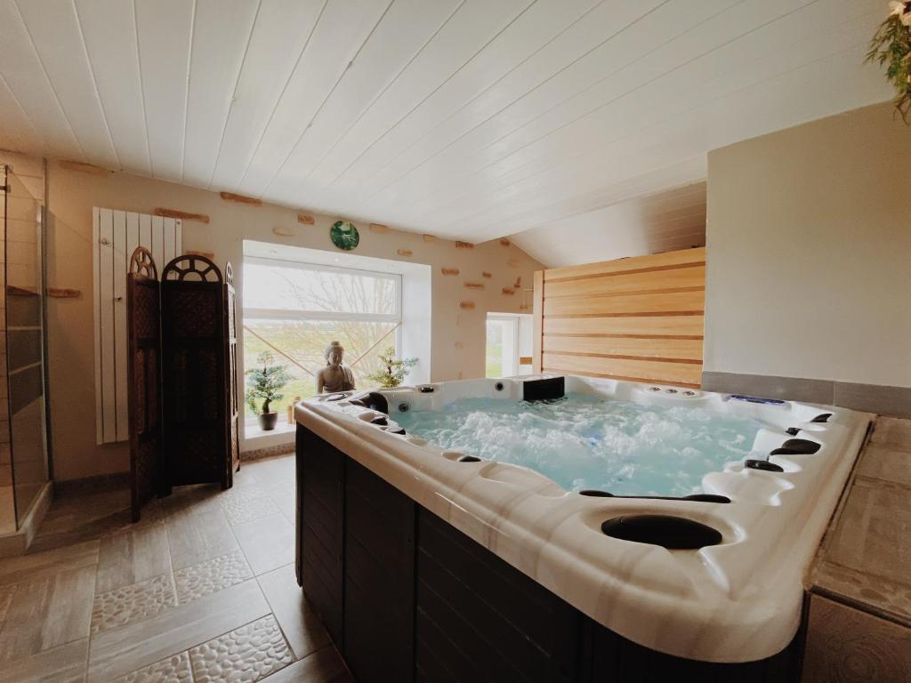 - une grande salle de bains pourvue d'une grande baignoire dans l'établissement Gite de Saint Florent - Piscine & Spa, à La Charrière