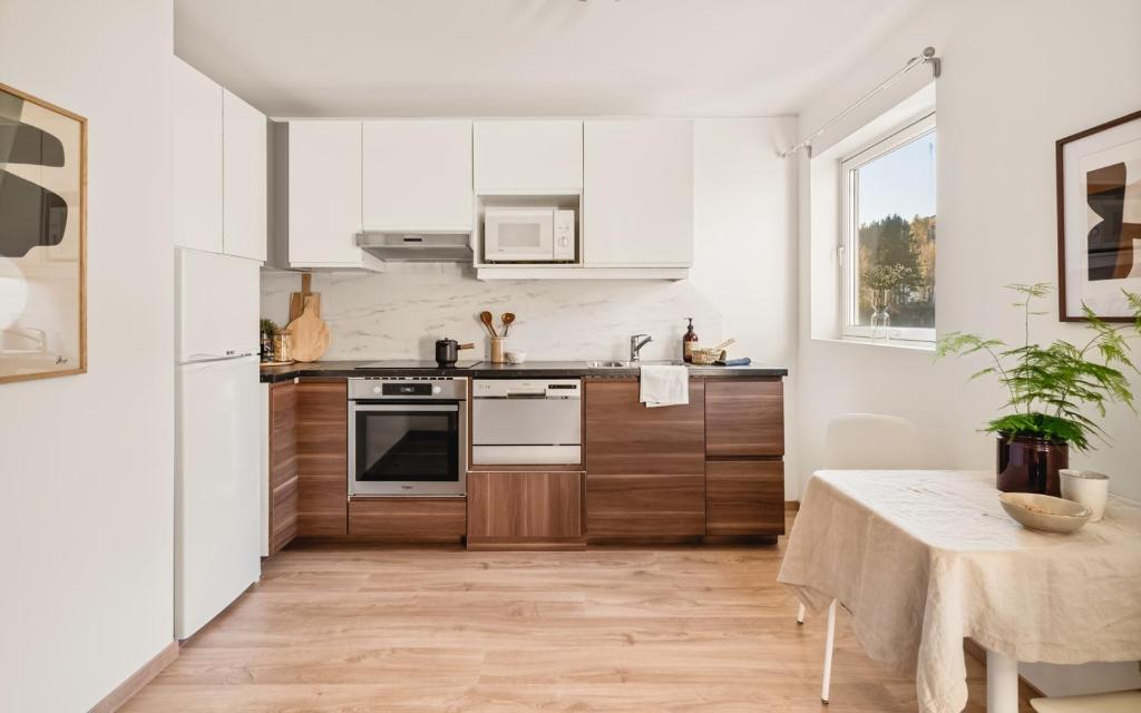 a kitchen with white appliances and a table with a tablecloth at Charming Peacful studio in Bergen