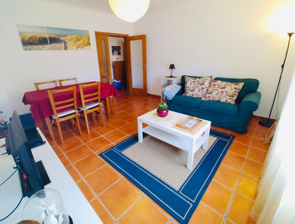 sala de estar con sofá azul y mesa en Apartamento T2 - Grândola Vila Morena, en Grândola