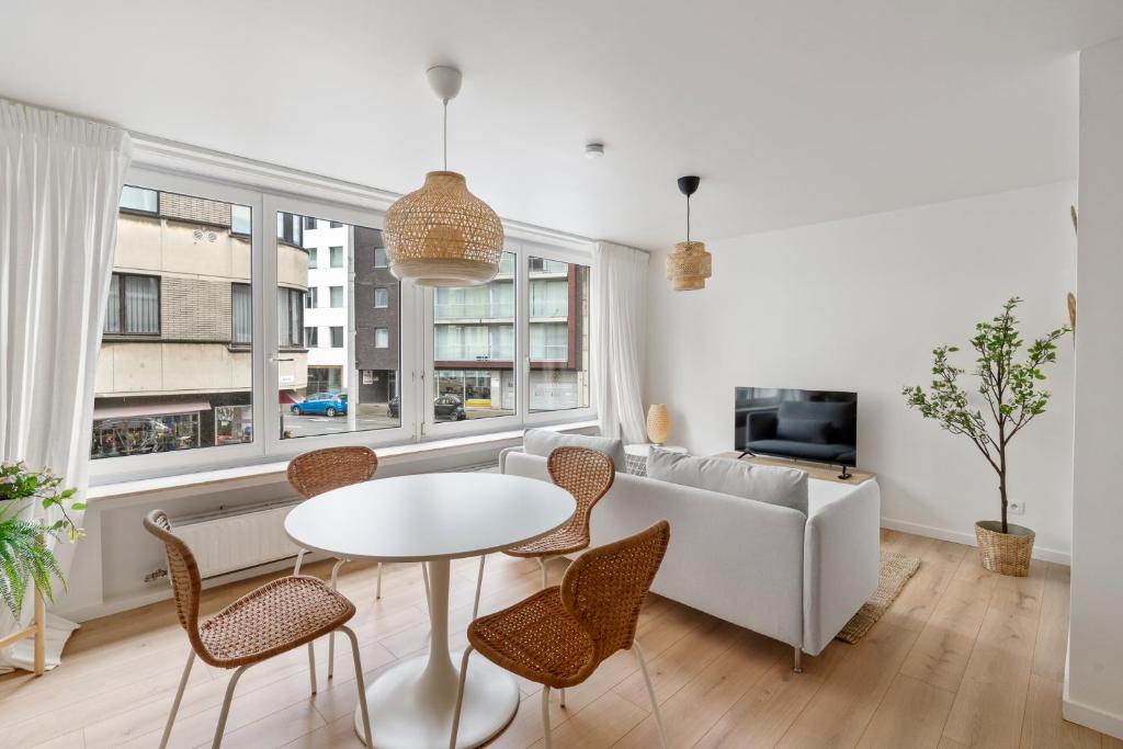 a living room with a couch and a table and chairs at Studio Petite Plage in Ostend